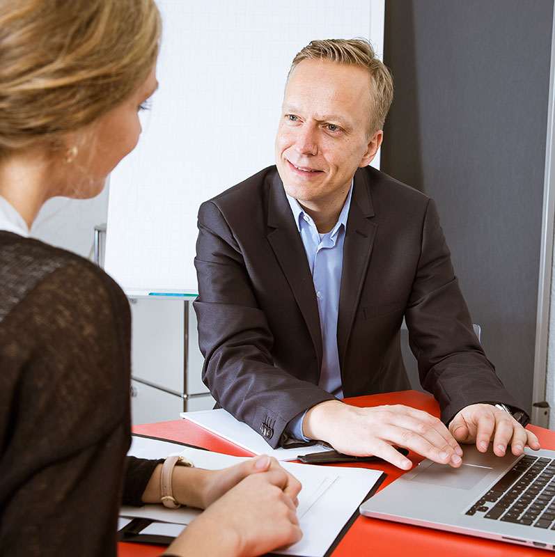 Beratungsgespräch am Schreibtisch mit Laptop
